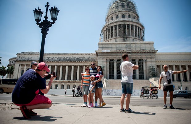 Turistas posam para fotos em frente ao Capitólio, em Havana (Foto: Yamil Lage/AFP)