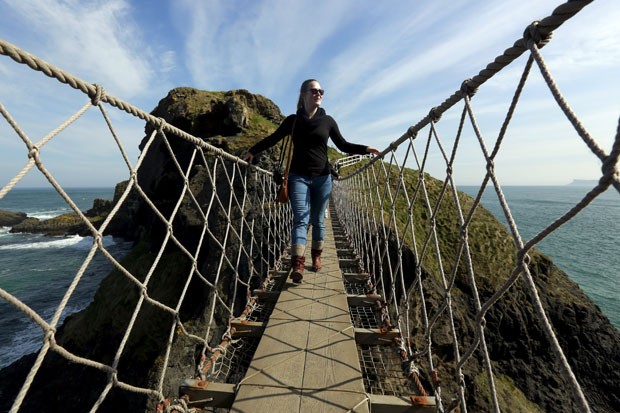 Turista atravessa a ponte Carrick-a-Rede na Irlanda do Norte nesta quarta-feira (8) (Foto: Cathal McNaughton/Reuters)