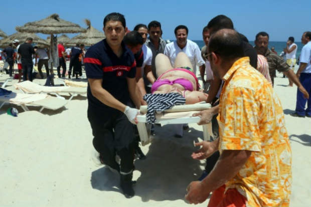 Equipes médicas tunisianas carregam mulher ferida em atentado em Sousse, em 26 de junho de 2015. Crédito: Mohammed Fliss/AFP