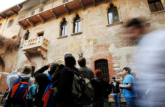 Turistas observam a casa de Julieta, em Verona, onde, segundo a lenda, Romeu a chamava sob a sacada