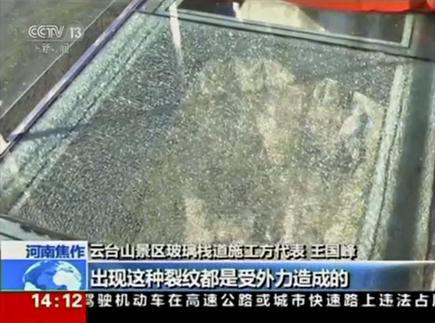 A view of cracked glass on a panel of the glass walkway at Yuntai Mountain Park in China's northern Henan province is seen in this still image obtained from video October 7, 2015. An official at the park said on Wednesday that the glass walkway, which tourists reported a panel of which had shattered, met national safety standards during routine inspections, state media reported. REUTERS/CCTV via REUTERS TV CHINA OUT. NO COMMERCIAL OR EDITORIAL SALES IN CHINA TPX IMAGES OF THE DAY ORG XMIT: SIN102