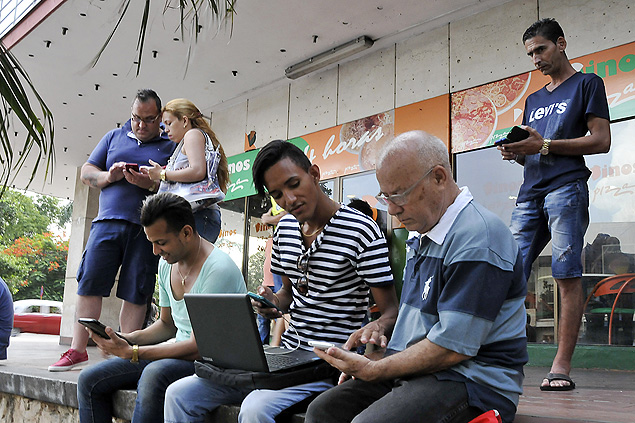 (150703) -- HAVANA, July 3, 2015 (Xinhua) -- People use mobile devices to connect to the Internet via WiFi in Havana July 2, 2015. Cuba's state-owned telecommunications company Etecsa has opened 35 public WiFi stops in the country. (Xinhua/Joaquin Hernandez) (vf)