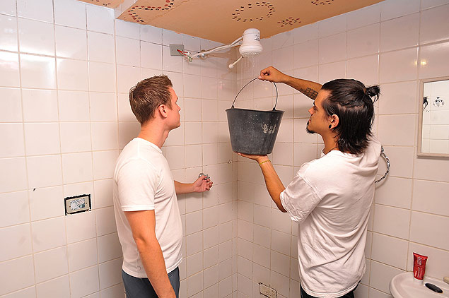 Hspede e funcionrio do Vila Madalena Hostel levam gua do banheiro para a cozinha 