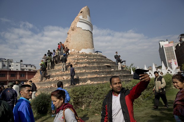  Homem tira selfie em frente a torre Dharahara, em Katmandu, no Nepal, nesta segunda-feira (27)  (Foto: AP Photo/Bernat Armangue)