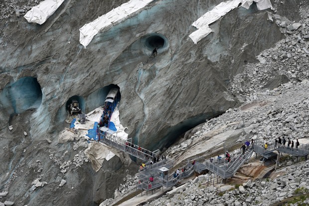  Visitantes passam por passarelas ao visitar a Caverna de Gelo, na geleira Mar de Gelo, no Mont-Blanc (Foto: AFP Photo/Philippe Desmazes)