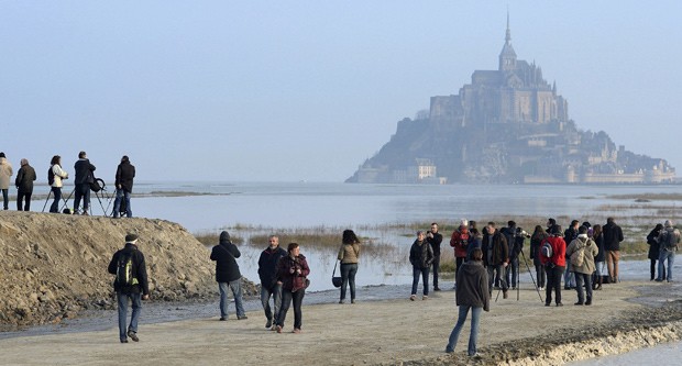  Monte Saint-Michel é visto ao fundo em foto deste sábado: maré alta deve encobrir ligação de monte com continente  (Foto: AP Photo)