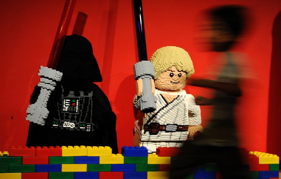 A boy runs in front of Lego-made Darth Vader (L) and Luke Skywalker (C), characters in the US movie Star Wars at LegoLand in Tokyo on September 15, 2013. The Lego Star Wars event started from September 14 to attract Star Wars fans. AFP PHOTO / RIE ISHII ORG XMIT: KIT137
