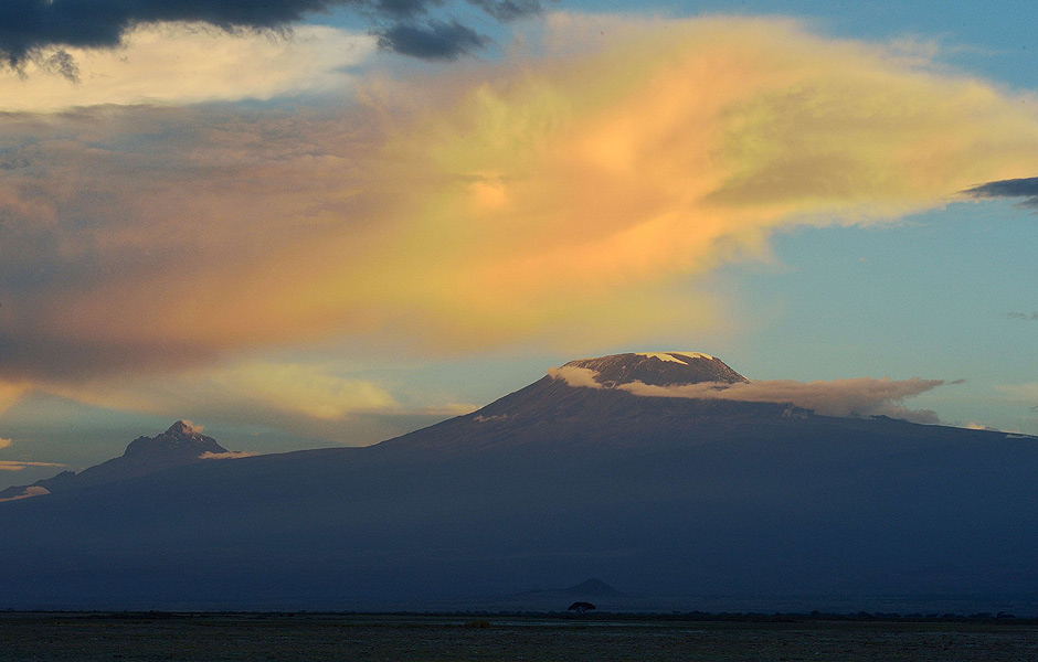 Africa's highest mountain, Kilimanjaro stands in the dying light of dusk over the rolling plains of the Amboseli national reserve November 13, 2015. The first delegation of the China-Africa Wildlife Ambassadors (CAWA) drawn from some of China's media corporations including JC Decaux China, iFENG.com, Beijing MTR Corporation, Shenzhen Press Group, Fulong Media and DEEP magazine arrived in Kenya as part of China's strategy to use iconic members of society to speak up against ivory trade and mobilizing society to stigmatize ivory consumption. In September this year, Chinese president Xi Jinping announced that China will take significant and timely steps to halt the domestic commercial trade of ivory thought to spur, on average, a killing of an elephant every 15 minutes for its ivory accirding to the International Fund for Animal Welfare (IFAW). AFP PHOTO/Tony KARUMBA ORG XMIT: TK25