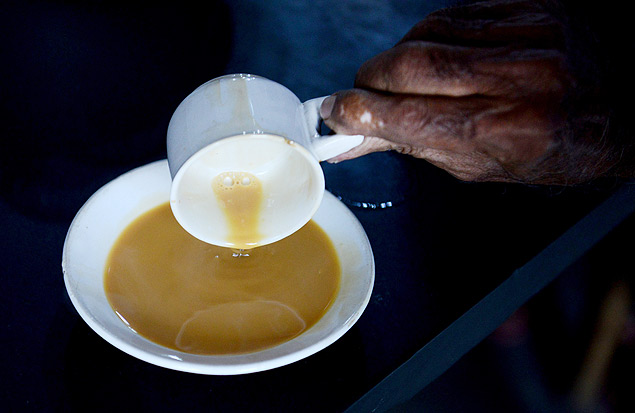 In this photograph taken on August 10, 2015, an Indian customer pours 'Irani chai-tea' into a saucer at The May Rose Cafe in Hyderabad. Irani chai defined the caf culture and it has been a tradition since the 1940s, from Secunderabd to the old city of Hyderabad. Introduced by settlers from Persia (Iran). Persian immigrants came to Mumbais port in search of a better life and to trade. From Mumbai they migrated to Pune and then to Hyderabad. Along with them came the concept of Irani chai. Irani chai is mostly served in a white ceramic cup and saucer and often called 90 ml chai after its standard volume, and costs in the range of Indian Rupees 10-12 (USD cents 0.16-0.19). AFP PHOTO/NOAH SEELAM ORG XMIT: NS014