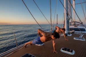 Tripulao aproveita a calmaria durante a travessia de Tonga para a Nova Zelandia para se exercitar no deck do veleiro (Heitor Cavalheiro/Divulgao Famlia Schurmann)